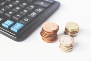 Three piles of coins near the calculator
